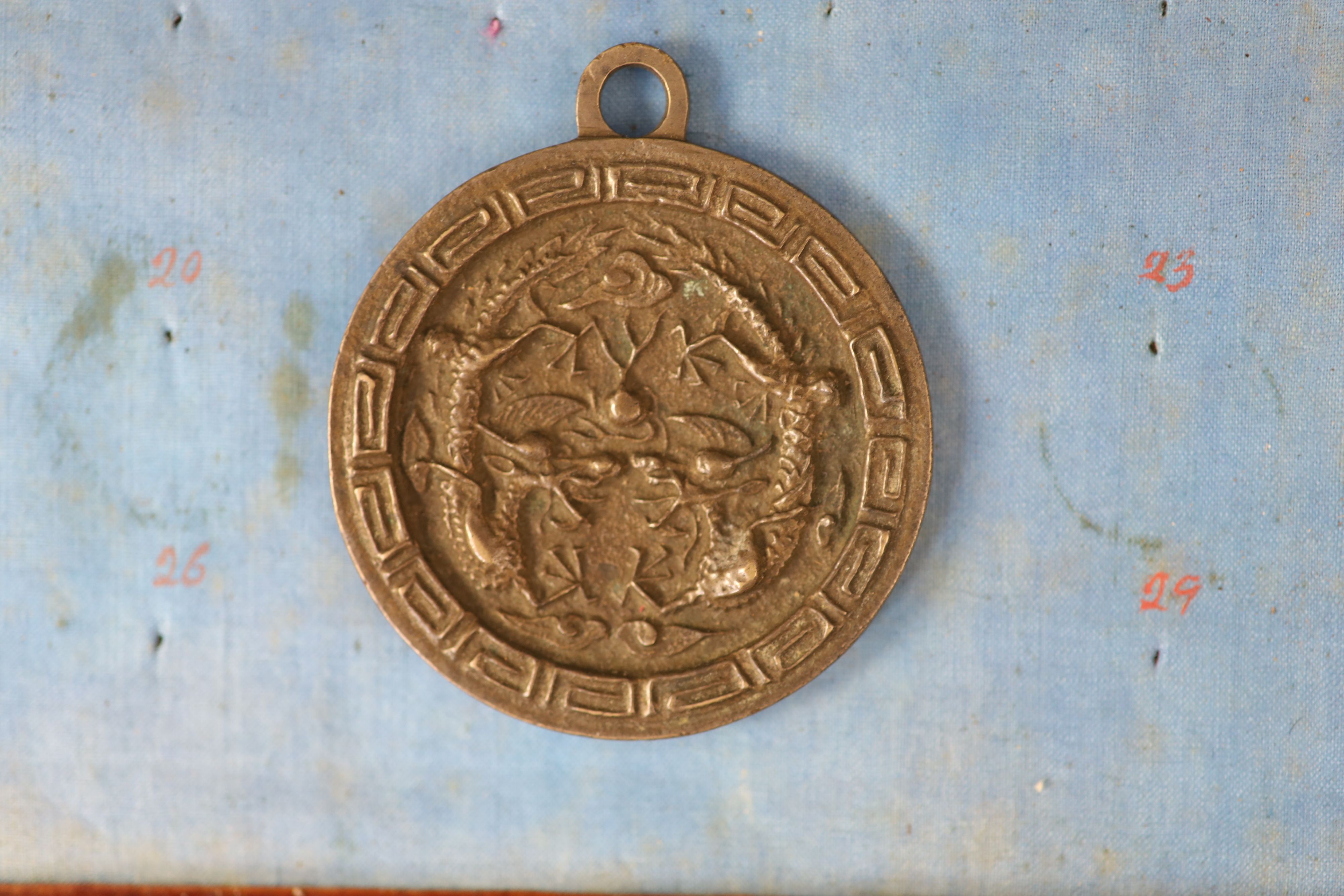 A group of 99 Korean bronze and metal amulets or charms, 19th/20th century